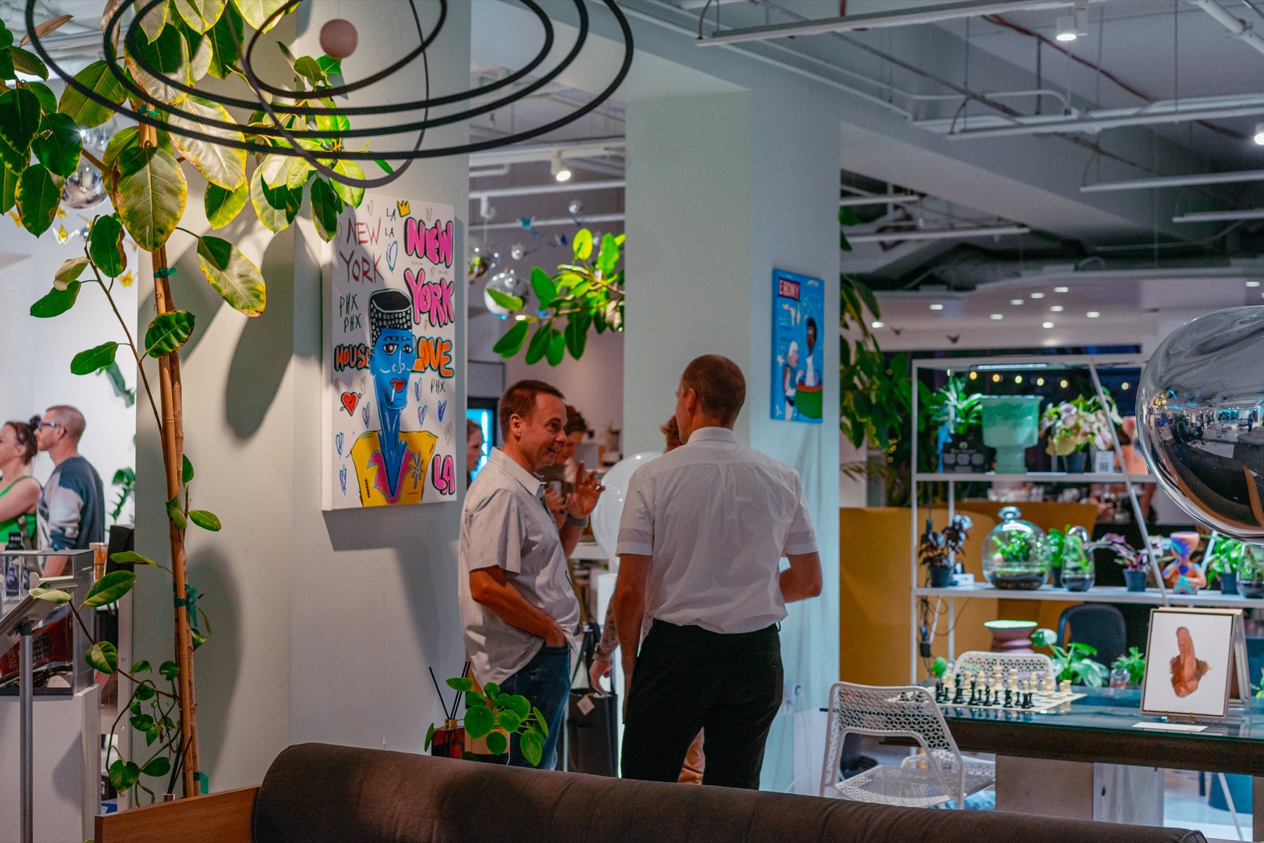 Visitors mingle among plants, art, furniture, and design objects inside Dialog.