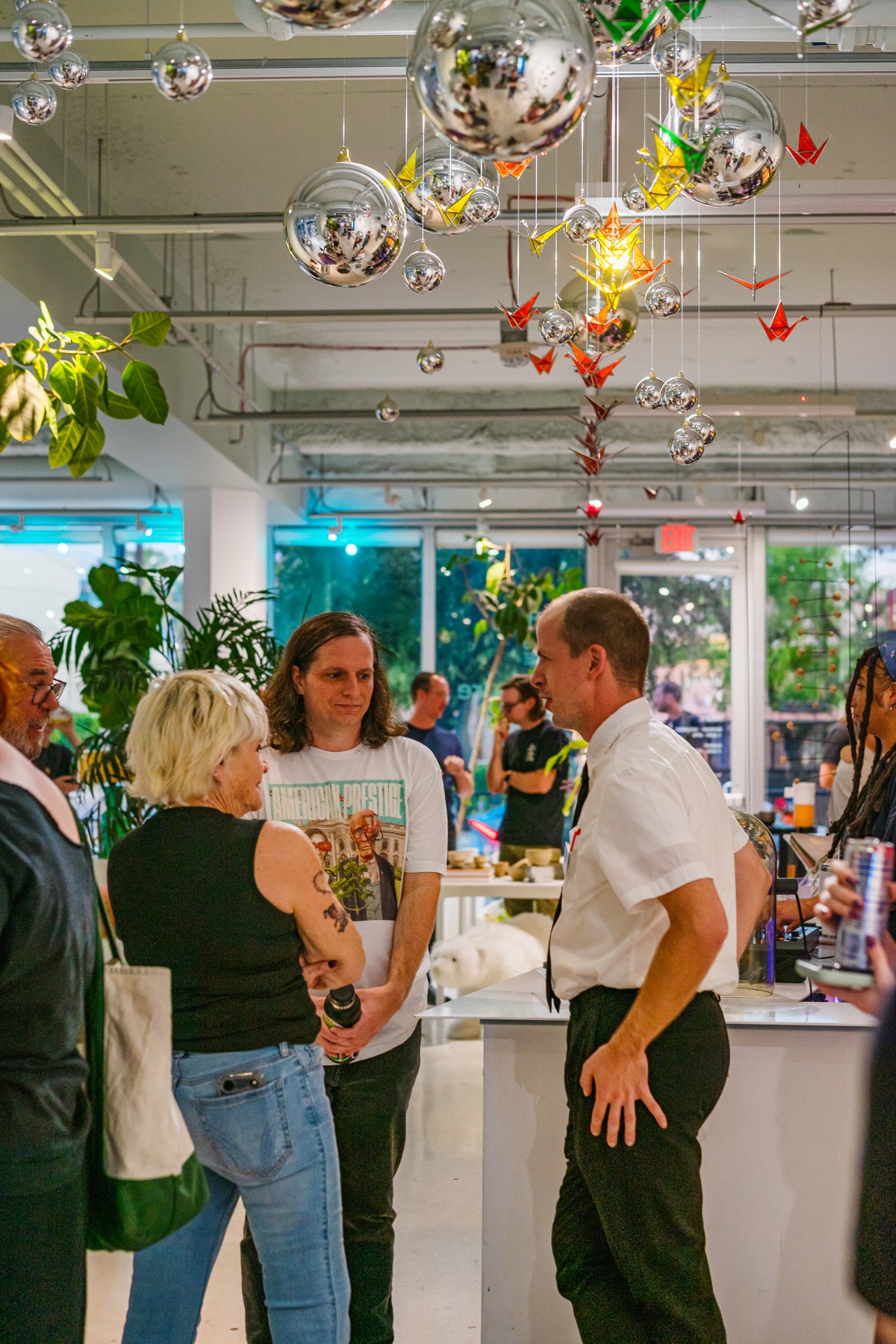 Opening-night visitors talk beneath the suspended ceiling installation.