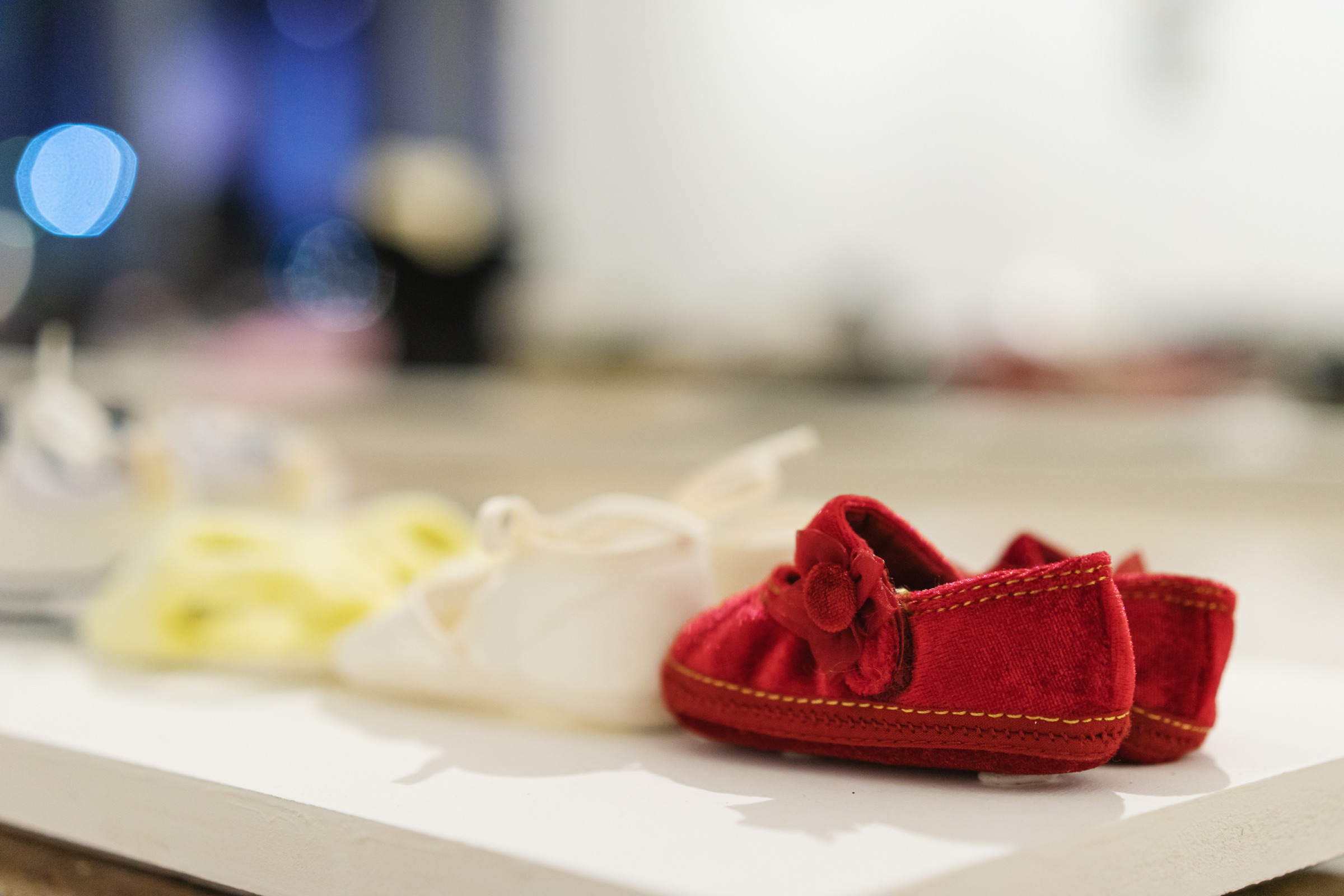 A tiny pair of red shoes sits at the edge of Heidi Dauphin’s shoe installation.