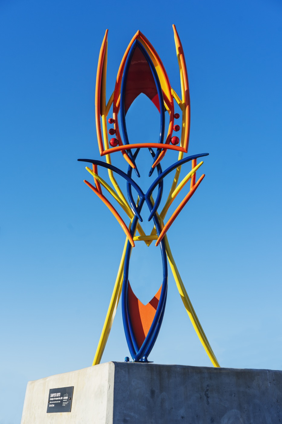 Nostalgia of the Inspired One, a colorful welded steel sculpture by Sawyer Boyd against a blue sky.